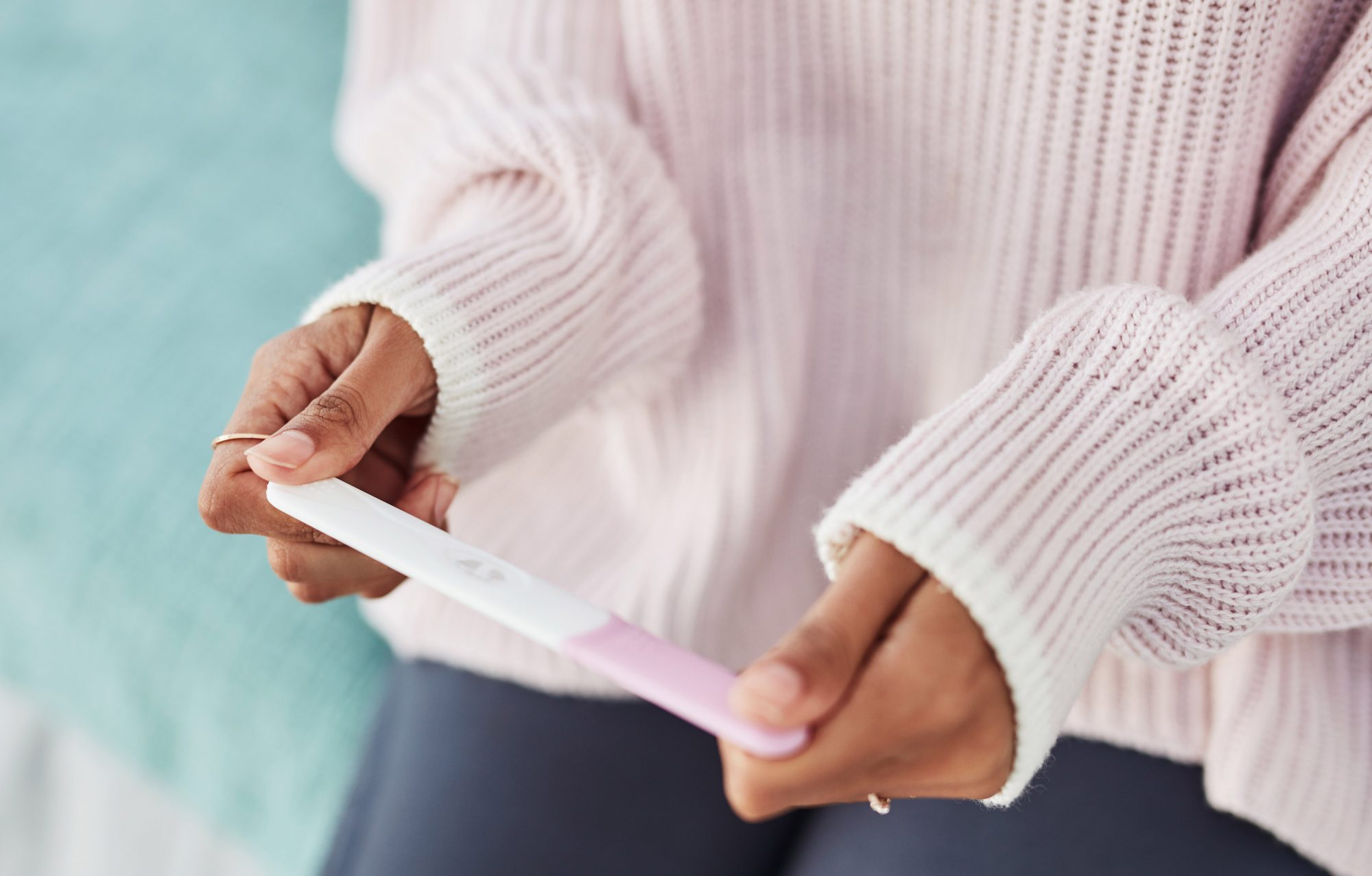 An image of a woman holding a pregnancy test.