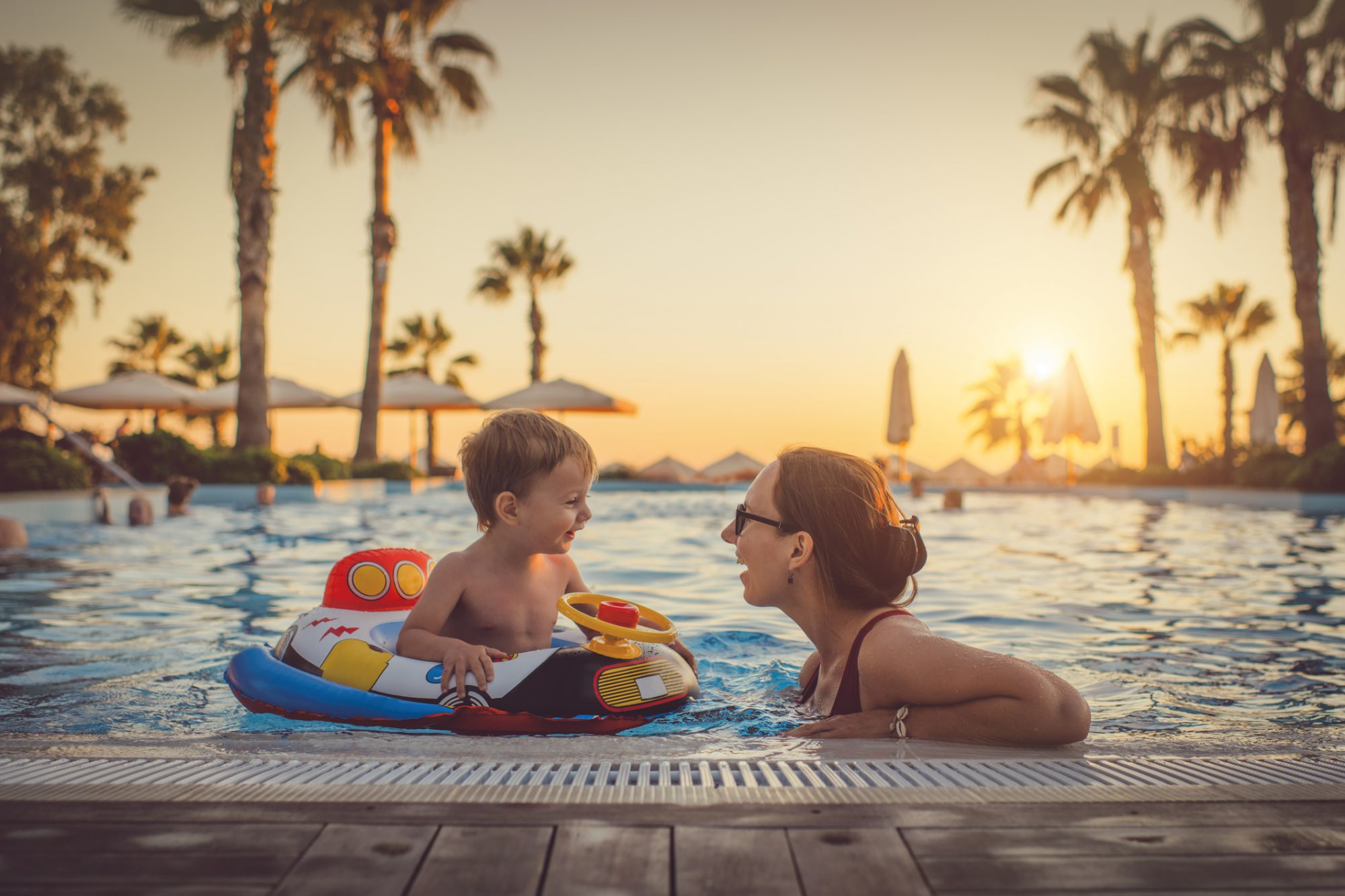 An image of a boy and his mother in a pool at a resort.