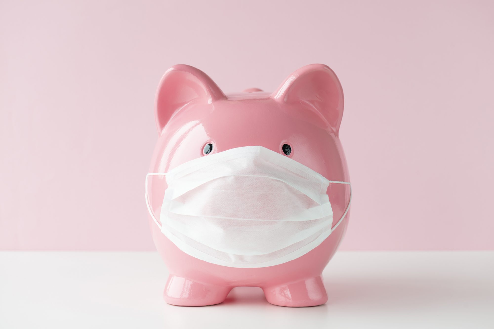 An image of a piggy bank with a mask on it.