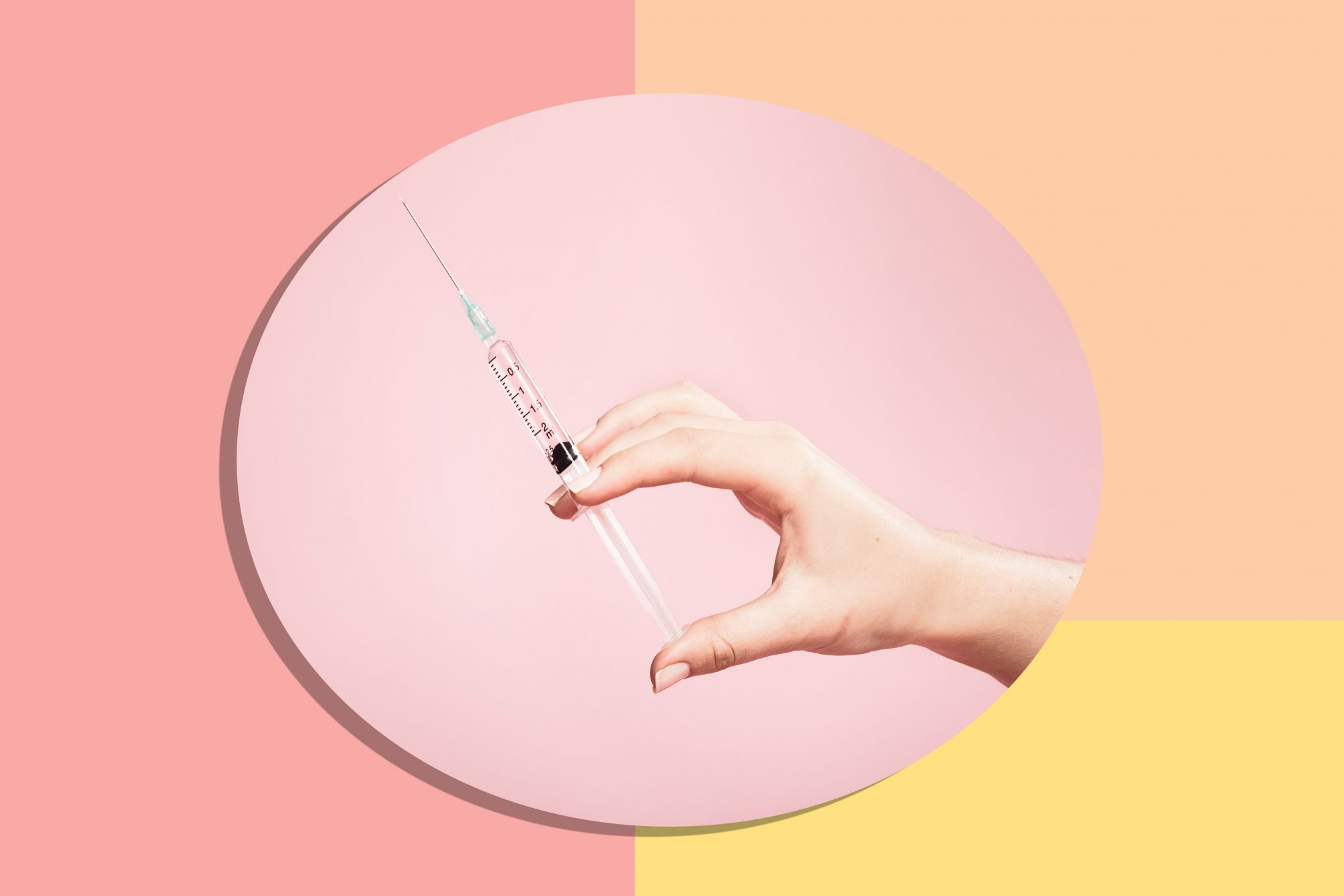 An image of a syringe on a colored background.